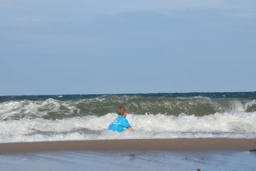 Kind - Junge badet im Meer bei hohen Wellen - Wellengang - Ostsee