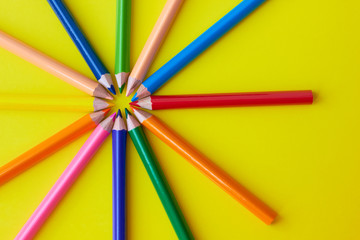 Naklejka premium Colored pencils on a yellow background.