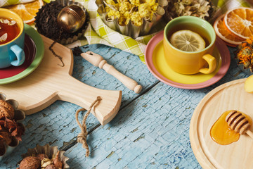 Cups with herbal tea and pieces of lemon, dried herbs and different decorations