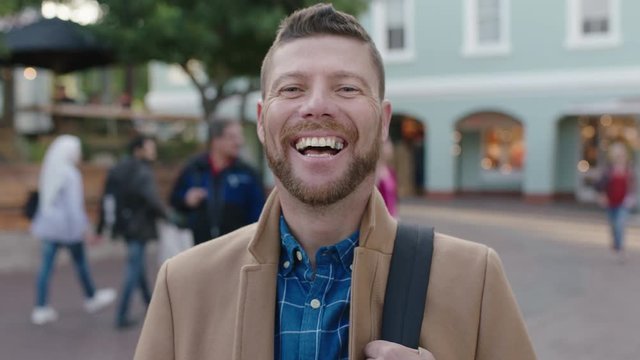 slow motion portrait of charming caucasian man laughing happy in urban background