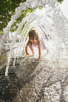 Girl passing underneath fountain