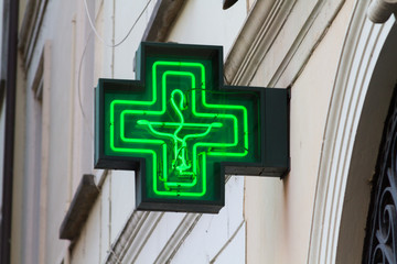 Pavia, Italy. 2018/2/13. A pharmacy sign -  a green cross - above a pharmacy in Italy.