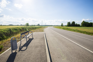 A bus stop on the country asphalt road on a sunny summer day, Latvia