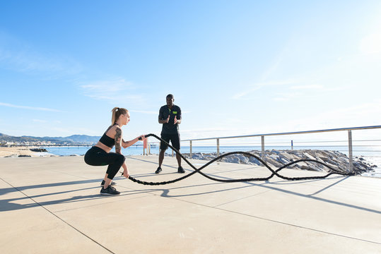 Woman training with instructor on seafront