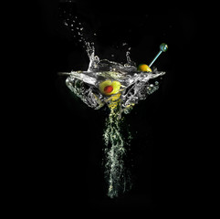 Imaginary wineglass with martini out of water splashes and air bubbles on black background