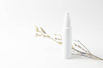 white perfume spray bottle packaging mockup with dried flower flora caspia on white background