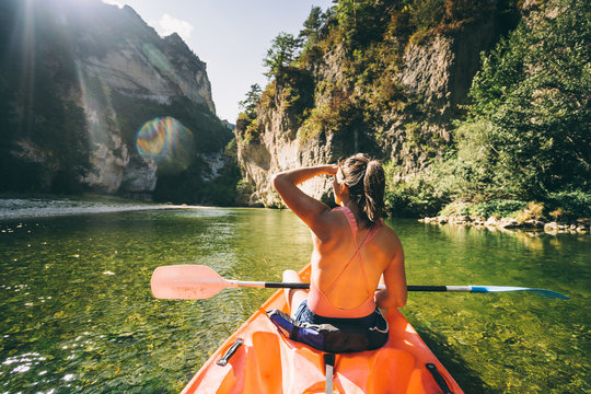 paddler in a canoe on a river in a lush green valley