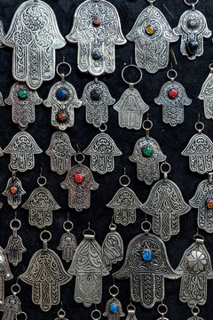 Fatima hands jewelry assortment in a souk market