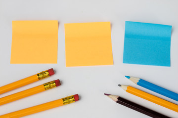 Pencil and sticky notes on a white table. Office accessories for saving notes.