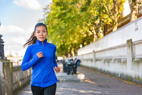 City jogging Asian runner running in London street. Active healthy lifestyle girl doing exercise workout outdoor. Motivation for weight loss, urban life.