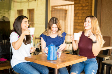 Girls laughing over a cup of coffee