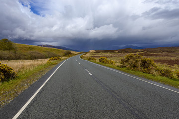 Country road with dramatic clouds in springtime on the Isle of Skye in Scotland, United Kingdom