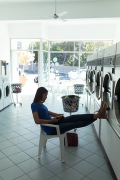 Woman reading a book at laundromat