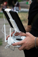 The operator controls the drone. The man operator is holding a control panel for the drone. The man...