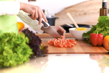 Close Up of human hands cooking vegetable salad in kitchen on the glass table with reflection. Healthy meal, and vegetarian food concept