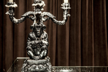 silver candle holder.with candles lit on a table.