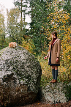 Young woman and cat on a stone