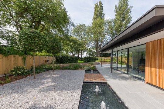 Side view of a modern domestic building viewed from the landscaped patio.