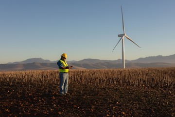 Engineer using mobile phone at wind farm