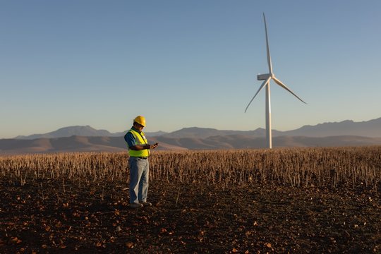 Engineer using mobile phone at wind farm