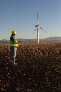Engineer using mobile phone at wind farm