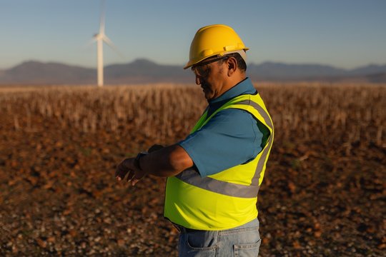 Engineer using a smart watch at a wind farm