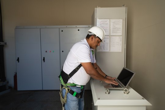 Engineer using a laptop inside the wind mill