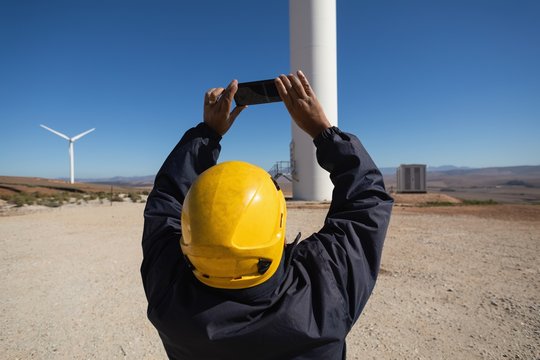 Engineer photographing a wind mill