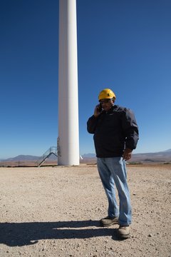 Engineer talking on mobile phone at wind farm