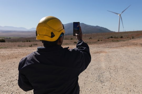 Engineer photographing a wind mill