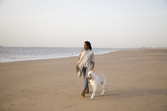 young woman on the beach with big white dog