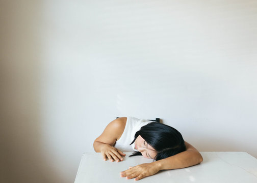 Death by self portrait ? young woman peacefully napping on table