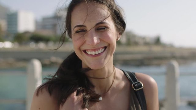 close up portrait of beautiful elegant woman laughing happy on sunny beachfront
