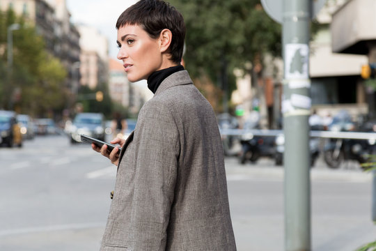 Stylish short haired business woman commuting between meetings on a busy city