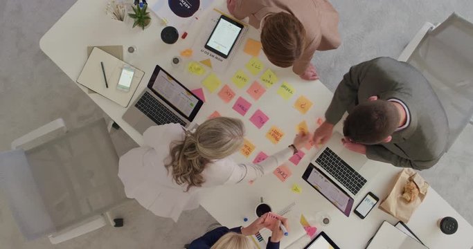 group of multi ethnic business people working together brainstorming strategy for innovative company making notes using colorful paper in boardroom meeting top view