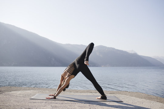 Woman doing variation of One-Legged Down Dog, Eka Pada Adho Mukha Svanasana