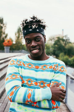 Outdoor Portrait of Smiling Young Black Man Wearing Colorful Jum