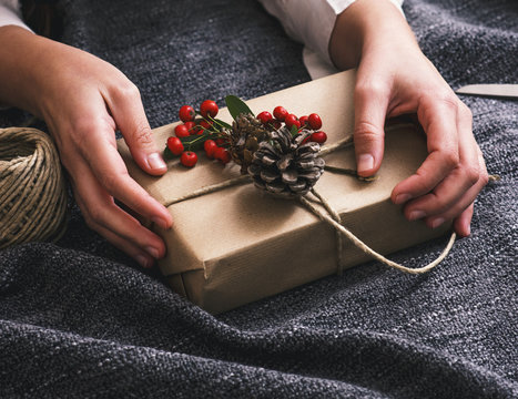 Top view of hands packaging one christmas present box.