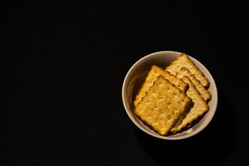 A plate of crackers on a dark background