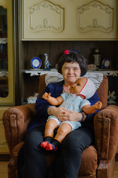 Portrait of a female model with down's syndrome holding her doll