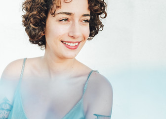 Portrait of a confident 
woman with curly hair