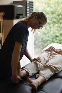 Physiotherapist giving a leg massage to senior woman