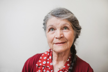 Portrait of content senior woman on plain white background