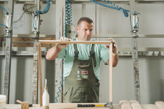 Man In The Uniform Working At The Furniture Factory