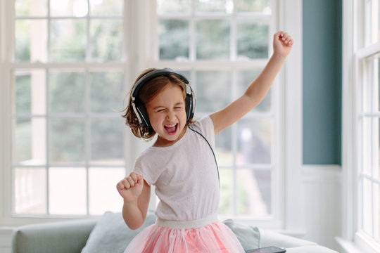 Cute young girl listening to music wearing headphones