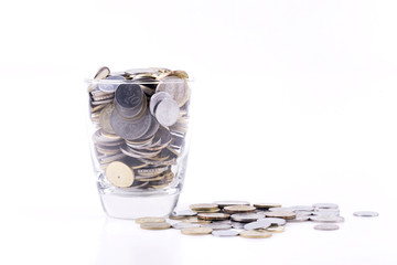 Money concept, coins inside or with the glass isolated over white background