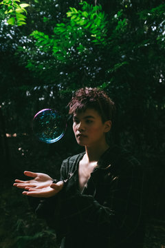 fashion man portrait in forest with a bubble