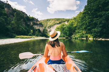 paddler in a canoe on a river in a lush green valley