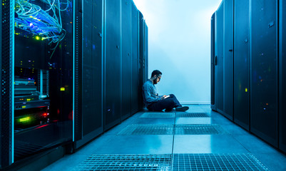 Technician entering data on a digital tablet in a server room