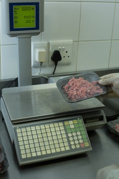 Butcher Checking Weight Of Packed Meat